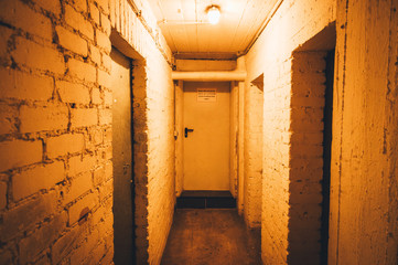 Cellar with a padlock and a cellar door in a tenement with a light switch in violet optics