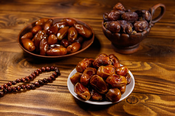 Dates fruit and rosary on wooden table