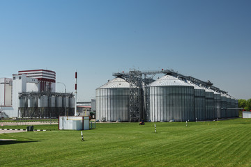 Large modern plant for processing grain crops. Industrial landscape. Row of granaries in sunny summer day