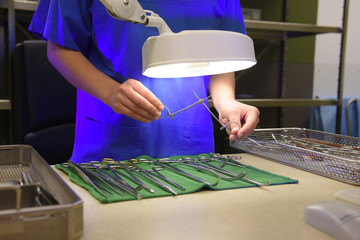 A young woman works in a hospital as a  medical hygiene worker. She is dressed  in special medical hygiene clothing and  carries out hygiene disinfecting and logistic tasks.