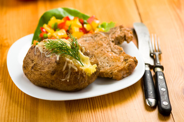 roasted pork chop and potatoes with stuffed skin