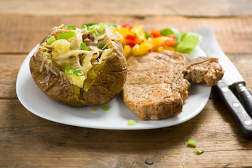 roasted pork chop and potatoes with stuffed skin