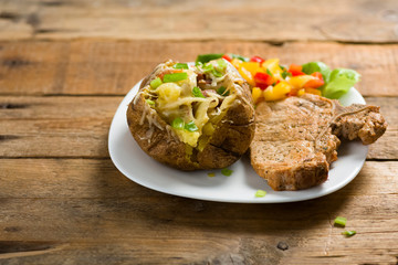 roasted pork chop and potatoes with stuffed skin