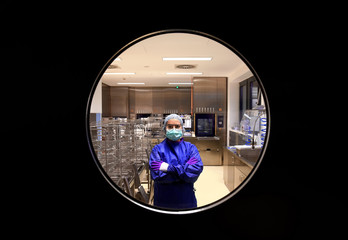 A young woman works in a hospital as a  medical hygiene worker. She is dressed  in special medical...