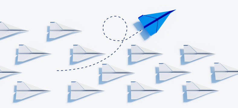 Blauer Papierflieger beim Kurswechsel