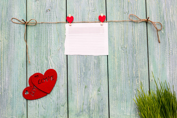 Valentine's day card with wood background, red hearts, rope and clothespins 