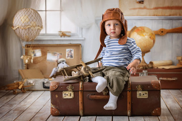 Boy in the pilot with the airplane plays in his room