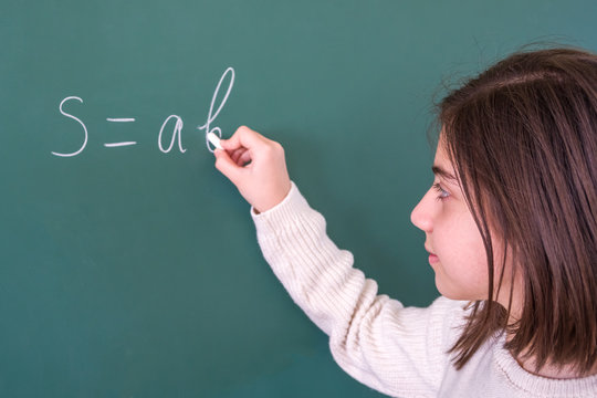 Beautifull girl resolves mathematical task on board