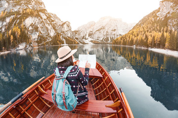 Asian hipster Girl looking to the map inside wooden boat or canoe kayak tour at the background of...