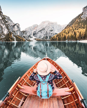 Happy Asian Woman Sitting In Wooden Vintage Boat Floating And Sailing On A Braies Lake In Italian Alps Mountains, Travel And Dream Vacation Concept