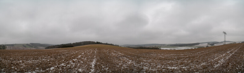 Naklejka na ściany i meble Panorama of the field in the fall. Arable land covered with snow