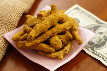 turmeric pieces and $ 100 dollars,turmeric pieces and white for $ 100 USD on a platter, turmeric pieces have increased,