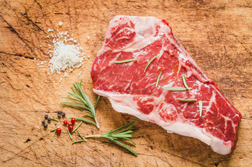 Raw angus meat steak on wooden board copy space.