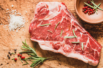 Raw angus meat steak on wooden board copy space.