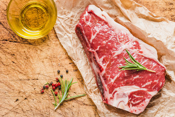 Raw angus meat steak on wooden board copy space.