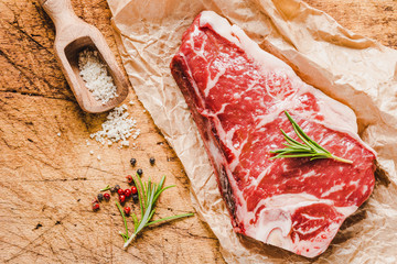 Raw angus meat steak on wooden board copy space.