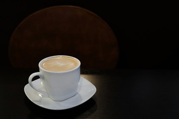 Cup of coffee with milk on a wooden table and a place for text