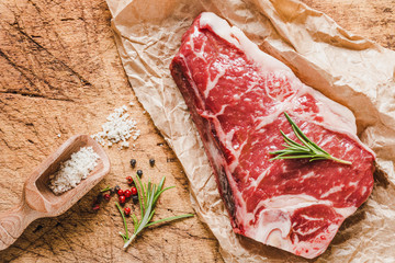 Raw angus meat steak on wooden board copy space.