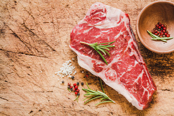 Raw angus meat steak on wooden board copy space.