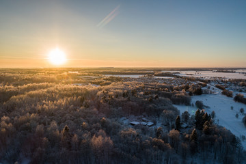 Fototapeta premium Aerial view of a beautiful sunset in the winter forest. 