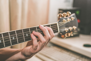 A man shows a chord on the neck of a guitar