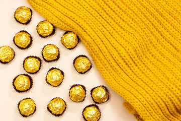 golden premium chocolate sweets under woolen winter scarf