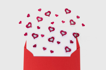Red envelope with red hearts flying out from it. Valentine's day concept. Love letter. Proposal. Wedding anniversary.