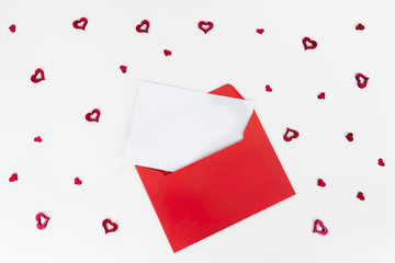 Red envelope with rblank white card inside surrounded by red hearts. Valentine's day concept. Love letter. Proposal. Wedding anniversary.