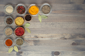 Spices and seasonings on the gray wooden background. Place for text.