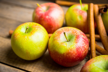 Apples with cinnamon on rustic wooden background. Selective focus. 