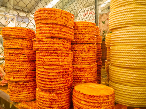 Stacks of cheese wheels cheese truckles. Queso de Cincho (Queso Guerrero) Cincho Cheese for sale in a market in Iguala, Guerrero. Travel in Mexico, Mexican food, firm cheese.