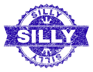 SILLY rosette seal overlay with distress style. Designed with round rosette, ribbon and small crowns. Blue vector rubber print of SILLY caption with scratched style.
