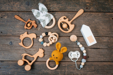 Baby first wooden toys, beanbags and teethers on rustic background