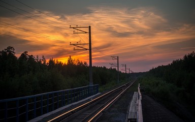 sunset in the clouds over the railway
