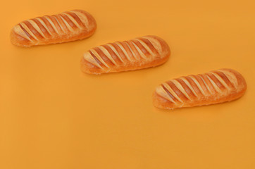 Three wheat breads on an orange background