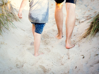 father and son walking up on the seaside