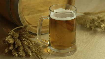 Oktoberfest beer barrel glasses with wheat and hops on wooden table