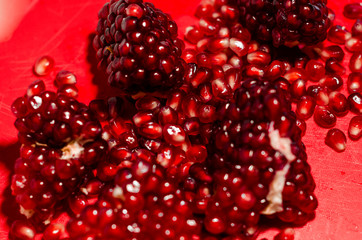 Opened and cutted pomegranate on the red board