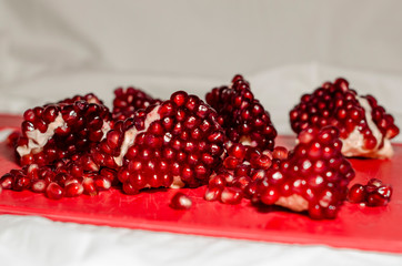 Opened and cutted pomegranate on the red board