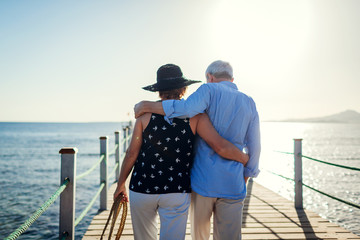 Senior couple walking on pier by Red sea. People enjoying vacation. Valentine's day