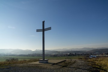 Fototapeta na wymiar Iron cross statue on the meadow above the city. Zilina, Slovakia