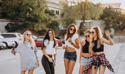 Five young women dance in a car park