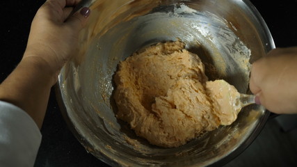 The process of obtaining a yellow dough for the French dessert macaroon mixing in an iron bowl