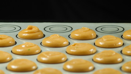 Traditional Christmas themed french macaroons on a baking dish.