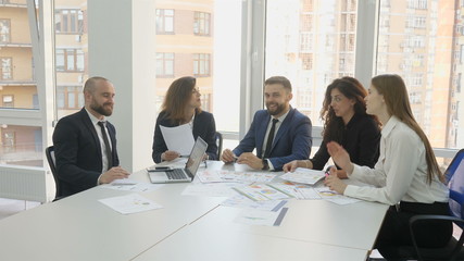 Office workers, employees of a large company, two young men and three young women, the end of the meeting men shake hands the rest clap, a successful contract, a top company, a young team