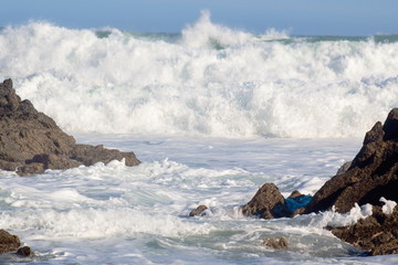 Fototapeta na wymiar Landscape image of Ocean Waves Crashing against Coastal Rocks at Cape Palliser, Wellington, New Zealand.