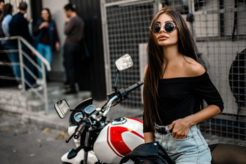 Fototapeta na wymiar Pretty young sexy fashion model posing on the motorcycle.