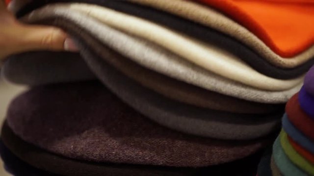 hats - berets of different colors. Women's hands choose a hat