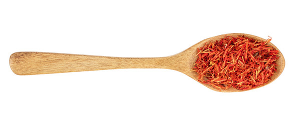Heap of saffron in wooden spoon isolated on white background. Top view. Flat lay