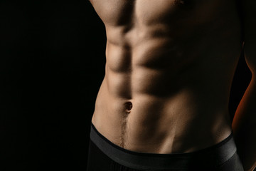 pumped handsome male press. Male athletic body closeup on black background